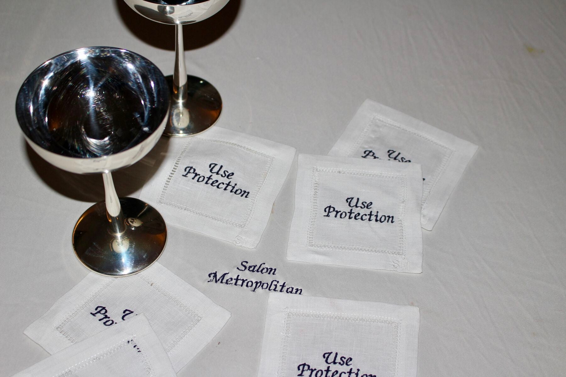 Cocktail napkins beside silver stemware